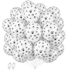 a bunch of white balloons with black dots on them