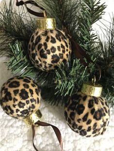 three leopard print ornaments hanging from a christmas tree