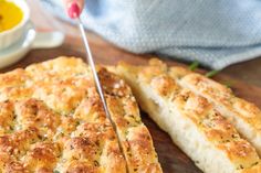 a person cutting bread with a sharp knife