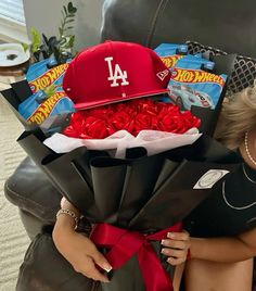 a woman holding a bouquet of roses and a baseball cap