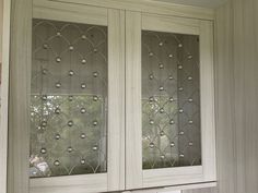 a kitchen cabinet with glass doors and drawers