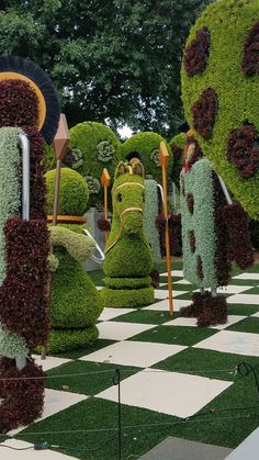 the topiary garden is made up of plants and grass, with flowers growing out of them