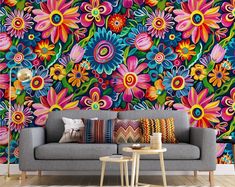 a colorful floral wallpaper in a living room with grey couch and coffee table next to it