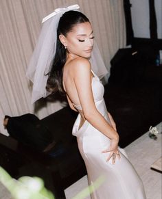 a woman in a wedding dress standing next to a couch