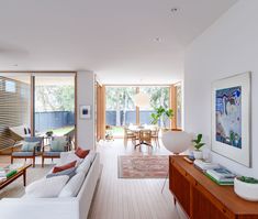 a living room filled with furniture next to a wooden table and large glass door windows