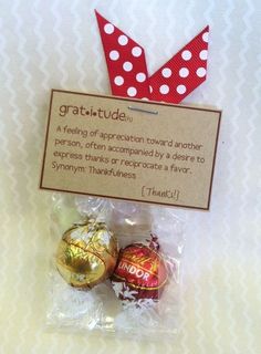 two chocolate candies wrapped in cellophane with a red polka dot bow on top