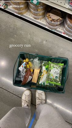 a person standing next to a grocery basket filled with food