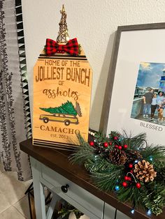 a holiday display with pine cones and christmas decorations on a table next to a sign that reads home of the jolliest bunch