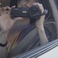 a man holding up a camera in his car