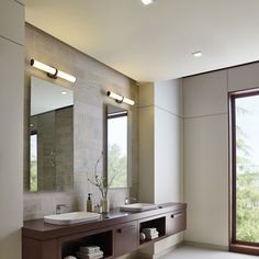 a large bathroom with two sinks and mirrors on the wall, along with an open window