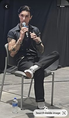 a man sitting in a chair holding a microphone