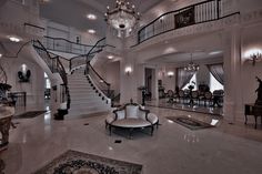 a large foyer with chandelier, marble floors and white walls on the second floor