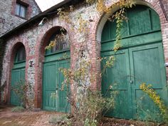 an old brick building with two green doors