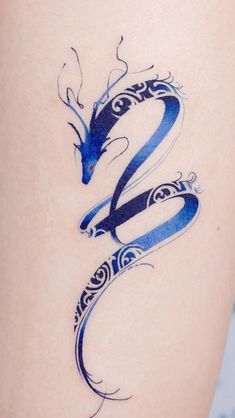 a woman's thigh with a blue dragon tattoo on it