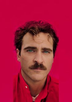 a man with a moustache on his face in front of a pink background