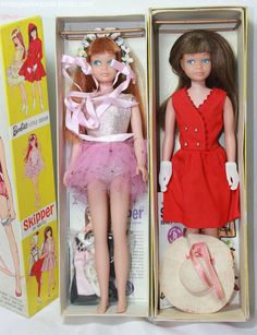 two dolls in boxes one is wearing a red dress and the other has a white hat