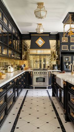 a large kitchen with black cabinets and gold trimmings on the walls, along with marble flooring