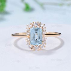 an aqua blue topazte and diamond ring on a white surface with flowers in the background