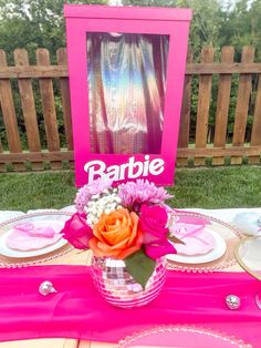 the table is set with pink and orange flowers