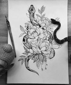 a drawing of a snake and flowers on paper