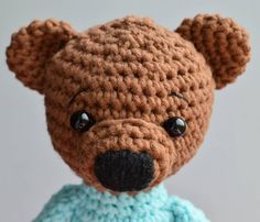 a crocheted teddy bear wearing a blue dress