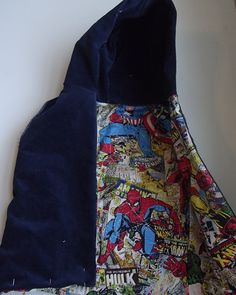 the back side of a blue jacket with comics on it