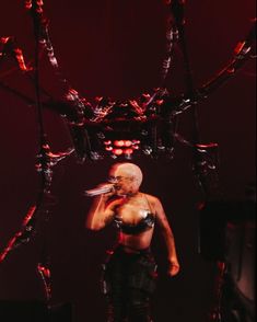 a woman standing on top of a stage holding a microphone in her hand and looking at the camera