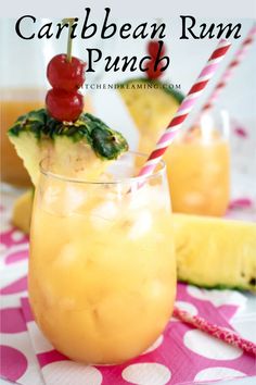 a glass filled with pineapple rum punch on top of a pink and white table cloth