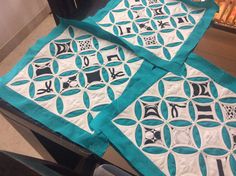 three quilts sitting on top of a table next to each other