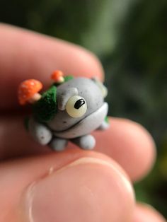 a tiny toy animal with broccoli and carrots on it's head