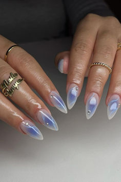 Gorgeous Milky White Stiletto Nails with a Purple Aura and Blue Marble Art, adorned with Sparkling Crystal Accents, creating a dreamy and ethereal look. // Photo Credit: Instagram @v.nailedit_ April Almond Nails, Eyeshadow Nails, Aura Nails, Blush Nails, Almond Nails Designs, Pretty Gel Nails, Blue Nail, Crystal Nails, Girls Nails