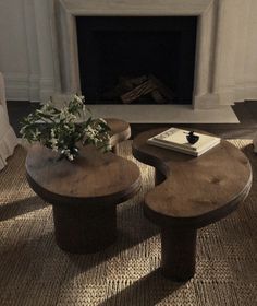 two wooden tables sitting in front of a fire place