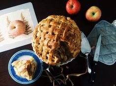 an apple pie sitting on top of a table next to two plates and utensils