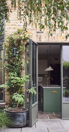 an open door leading to a kitchen and dining area with potted plants on the patio