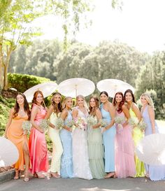 a group of women standing next to each other holding umbrellas