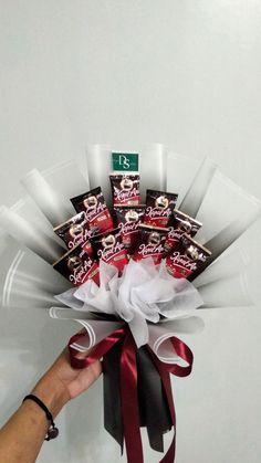 a hand holding a bunch of chocolates in it's wrapper and tied with ribbon