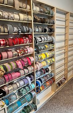 many different types of ribbons are on display in the store's shelving unit