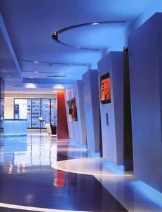 an empty lobby with blue lighting and large windows