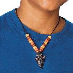 a man wearing a blue shirt has a necklace with a wooden bead on it