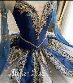 a blue and gold ball gown is on display