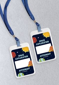 two space explorer tags with lanyards attached to them on a gray table top