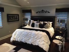 a large bed sitting in a bedroom next to two windows