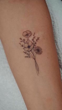 a woman's arm with a flower tattoo on the left side of her arm