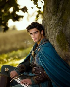 a man dressed in medieval clothing sitting under a tree