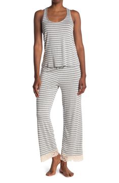 Lounge in ultimate comfort in this super soft scoop neck tank and pajama bottoms set. 2-piece set Top: 24" length; Pants: 13" rise, 29" inseam (size S) Top: scoop neck, sleeveless, racerback, knit construction, lace trim Bottoms: elasticized drawstring waist, pull-on style, knit construction, lace trim 95% rayon, 5% spandex Machine wash Imported Model’s stats for sizing: 5’11” height, 32” bust, 24” waist, 34” hips. Model is wearing size S. Sleeveless Tops With Elastic Waistband For Loungewear, Casual Sleeveless Sleepwear For Loungewear, Sleeveless Relaxed Fit Sleepwear, Relaxed Fit Sleeveless Sleepwear, Comfortable Relaxed Fit Tank Top For Loungewear, Casual Stretch Sleepwear For Pajama Party, Relaxed Fit Tank Top For Loungewear, Casual Sleeveless Sleepwear For Lounging, Pajama Bottoms