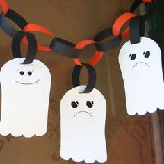 three ghost shaped paper tags hanging from a chain