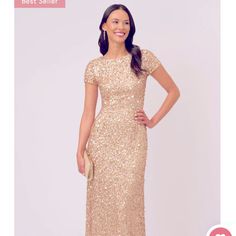 a woman wearing a gold sequin gown with short sleeves and an embellished neckline