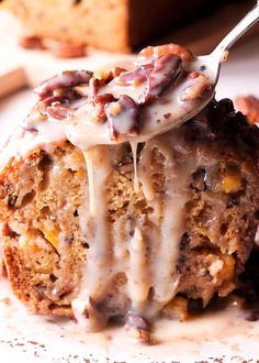 a piece of cake with icing and nuts is being held up by a fork