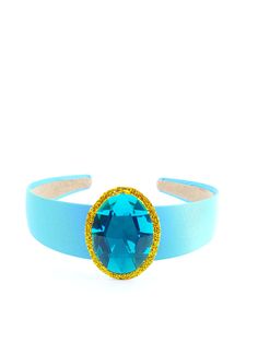 a blue and gold bracelet with an oval crystal stone on the center, sitting against a white background