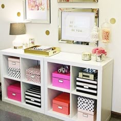 a white desk with lots of drawers and pictures on the wall above it, in front of a mirror